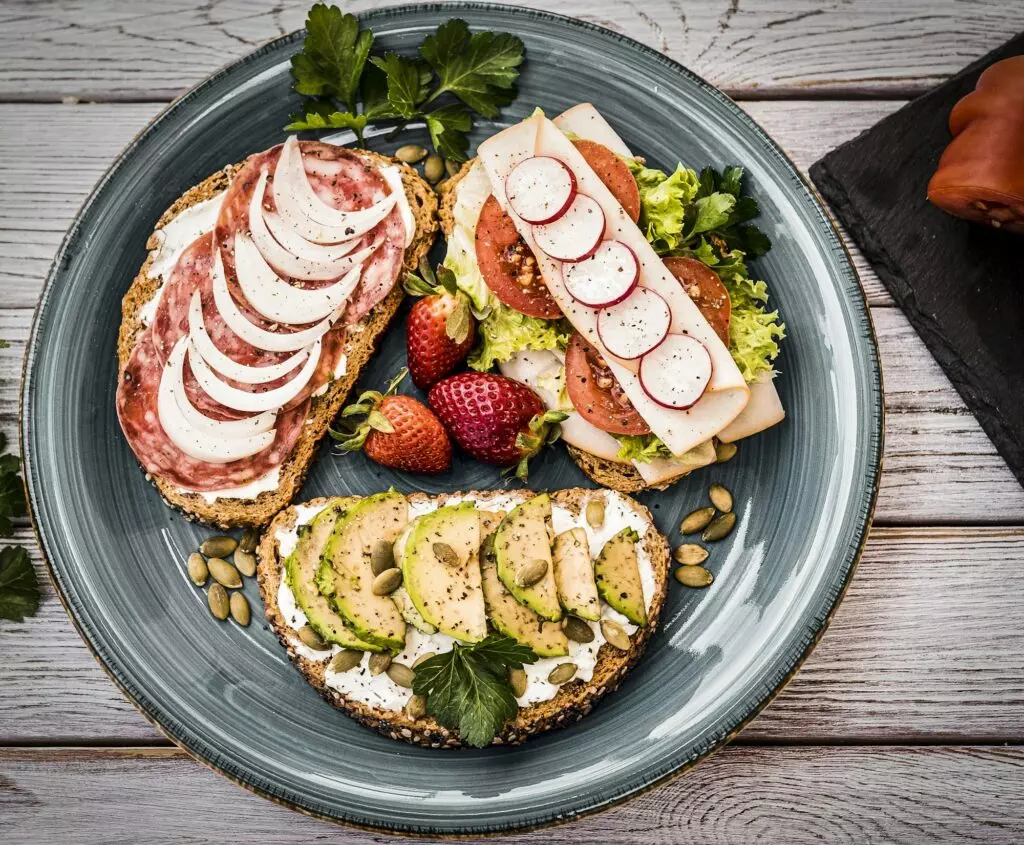 Top view of a plate with three types of dietetic sandwiches - whole wheat bread with seeds