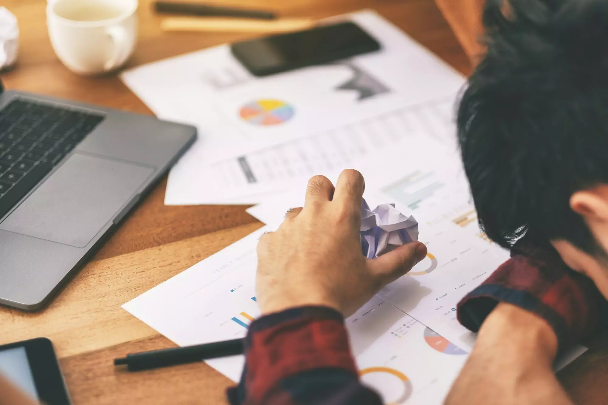 A businessman working with feeling frustrated and stressed with screwed up papers