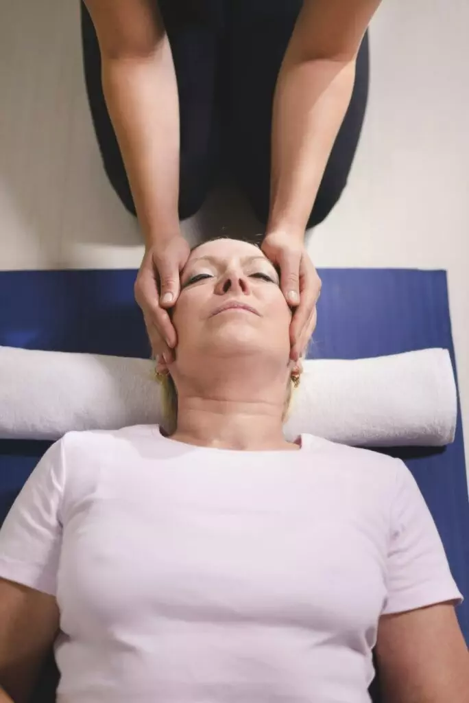 Therapist Doing Reiki Therapy To Senior Woman