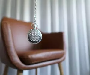 Photo by MK Hamilton silver round pendant on brown wooden chair